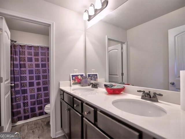 bathroom with hardwood / wood-style floors, vanity, and toilet