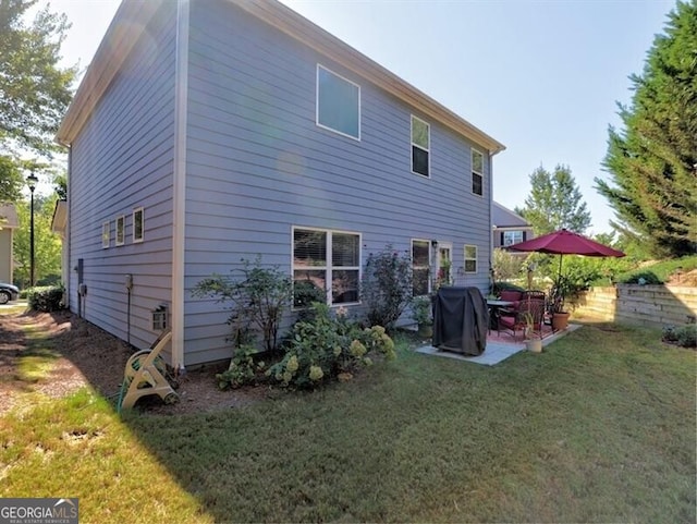 rear view of property featuring a lawn and a patio