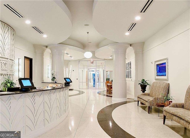 reception area featuring decorative columns and french doors