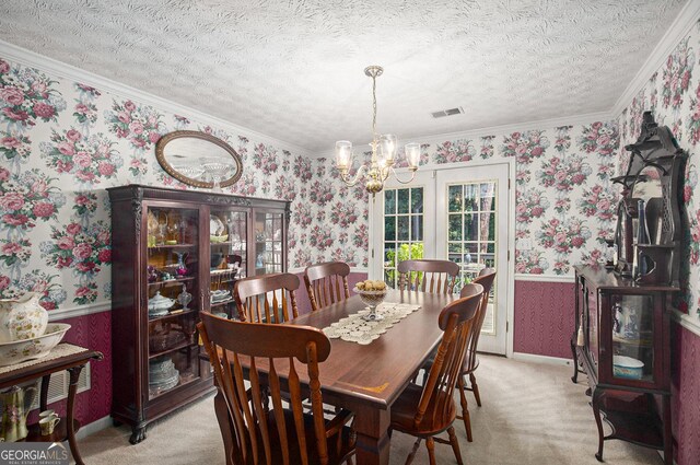 dining room with light carpet, a textured ceiling, a chandelier, and ornamental molding