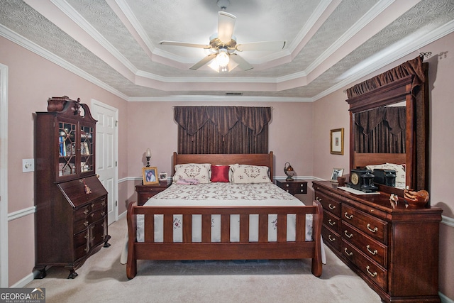 bedroom with crown molding, a tray ceiling, ceiling fan, and light colored carpet