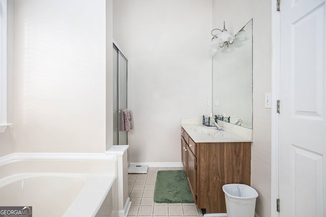 bathroom featuring tiled tub, vanity, and tile patterned floors