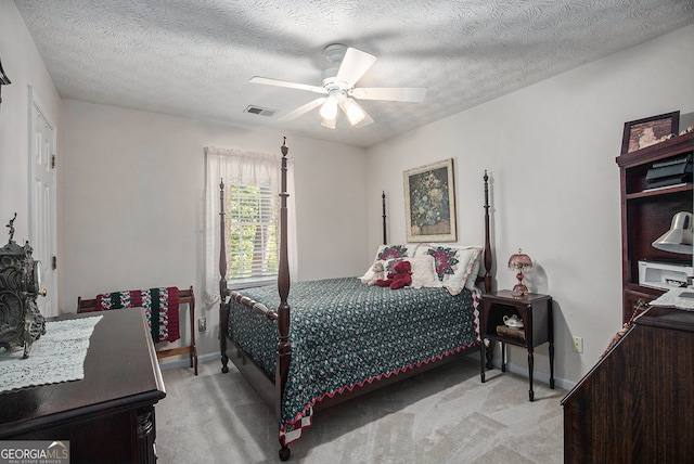 carpeted bedroom with ceiling fan and a textured ceiling