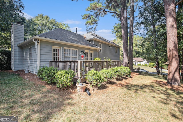 back of property featuring a yard and a wooden deck