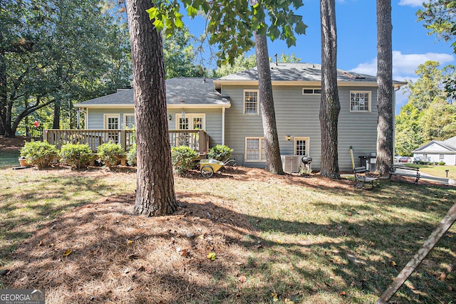 rear view of property with a deck, a lawn, and central air condition unit