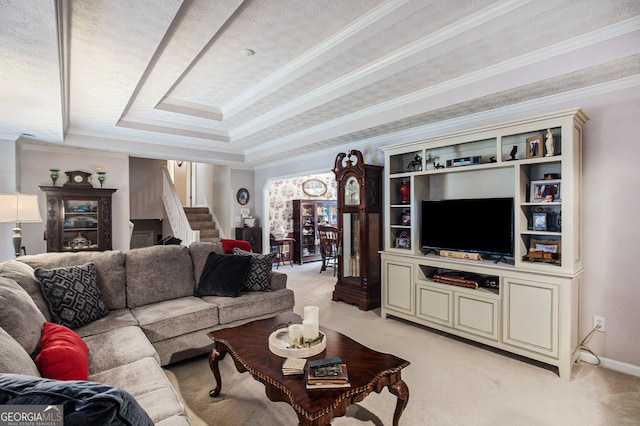 carpeted living room featuring a textured ceiling, ornamental molding, and a tray ceiling