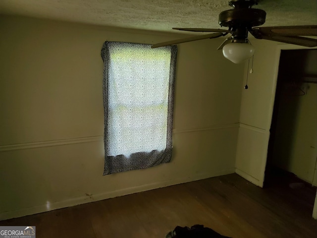 unfurnished bedroom featuring a closet, ceiling fan, hardwood / wood-style floors, and a textured ceiling