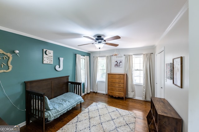 bedroom with dark hardwood / wood-style flooring, ceiling fan, and crown molding