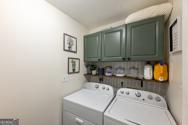 clothes washing area featuring cabinets and independent washer and dryer