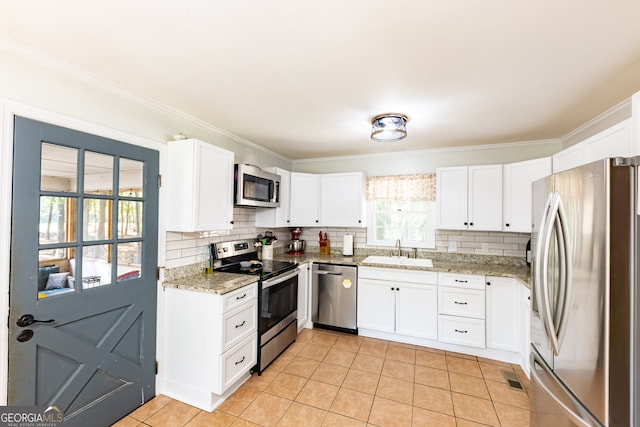 kitchen with white cabinets, sink, light stone countertops, light tile patterned floors, and stainless steel appliances