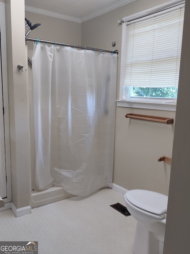 bathroom featuring crown molding, toilet, and a shower with curtain