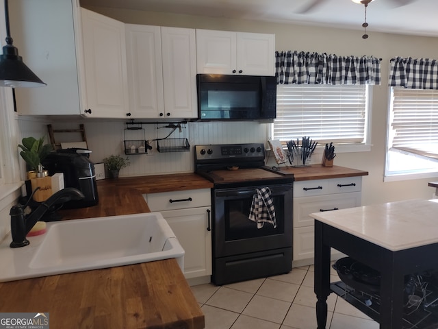 kitchen with black appliances, butcher block countertops, white cabinetry, and sink