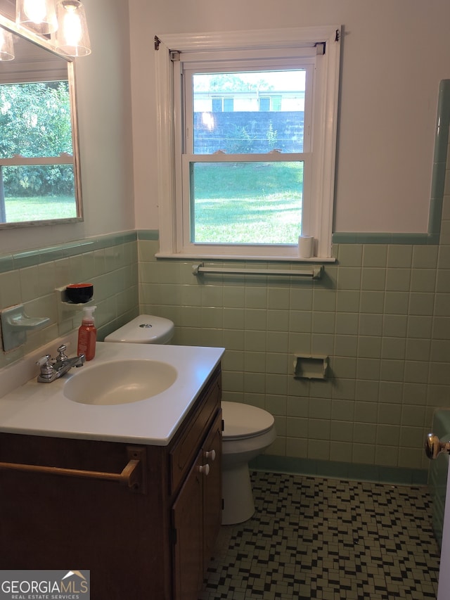 bathroom with vanity, tile walls, tile patterned flooring, and toilet