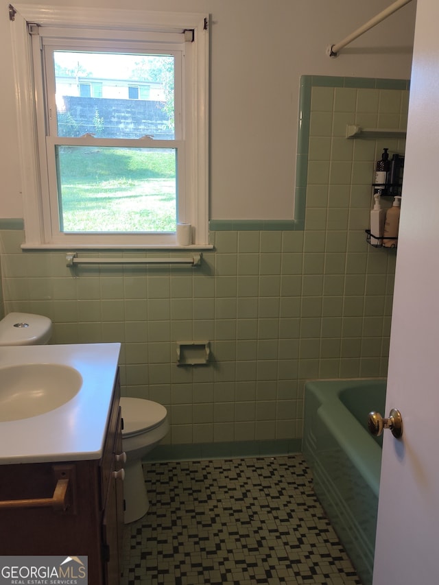 bathroom with tile walls, vanity, and toilet