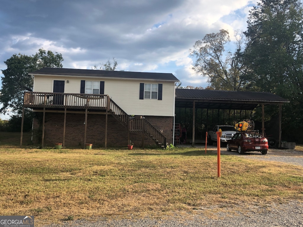 view of front of property with a carport, a front yard, and a deck