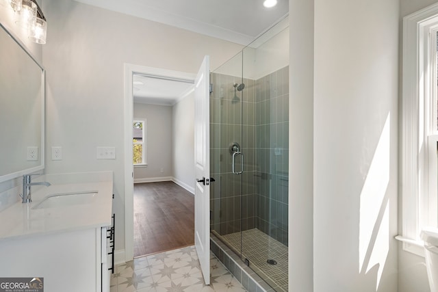 bathroom featuring vanity, crown molding, a shower with shower door, and hardwood / wood-style flooring