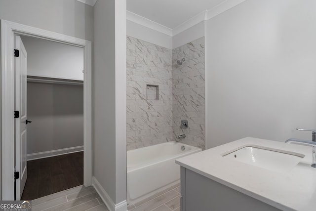 bathroom featuring ornamental molding, vanity, and tiled shower / bath