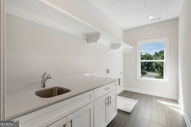 kitchen featuring white cabinetry and sink