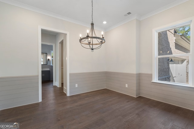 unfurnished dining area with an inviting chandelier, dark hardwood / wood-style floors, and ornamental molding