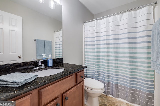 bathroom with walk in shower, vanity, and toilet