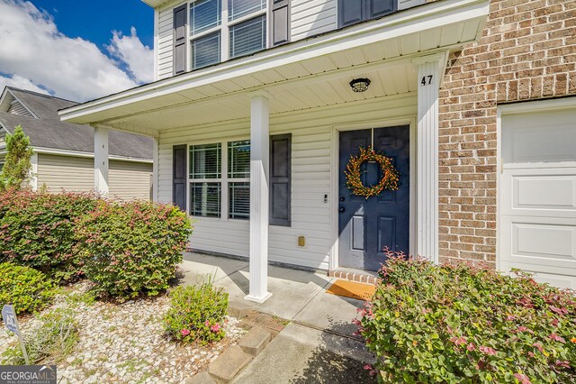 property entrance with a porch and a garage