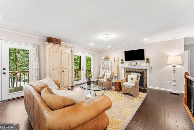 living room with a textured ceiling, crown molding, a fireplace, and dark wood-type flooring