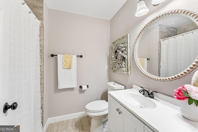 bathroom with walk in shower, vanity, and toilet