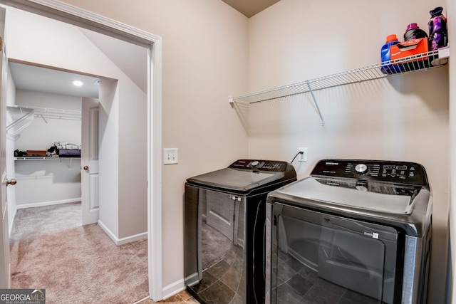 clothes washing area with light carpet and washer and dryer