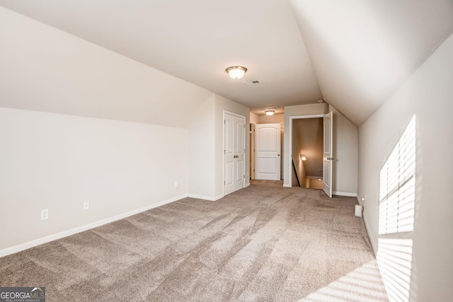 bonus room featuring vaulted ceiling and carpet flooring