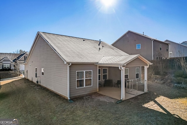 rear view of house with a patio and a lawn