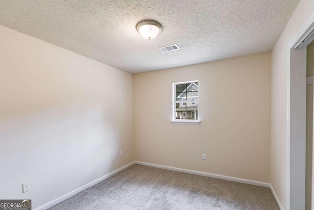 empty room featuring a textured ceiling and carpet floors