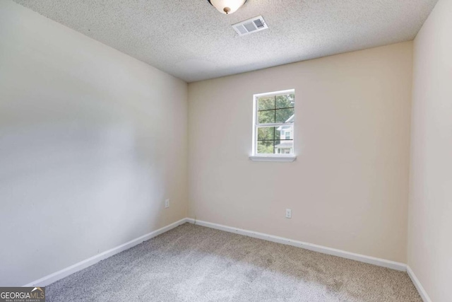 spare room with carpet floors and a textured ceiling