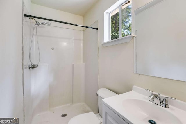 bathroom with walk in shower, vanity, and toilet