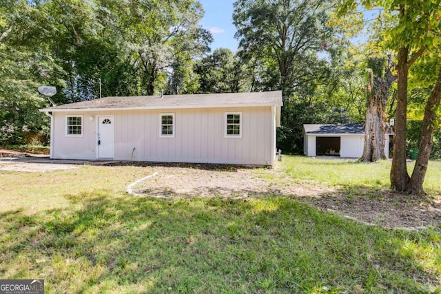 rear view of house with a yard and an outbuilding