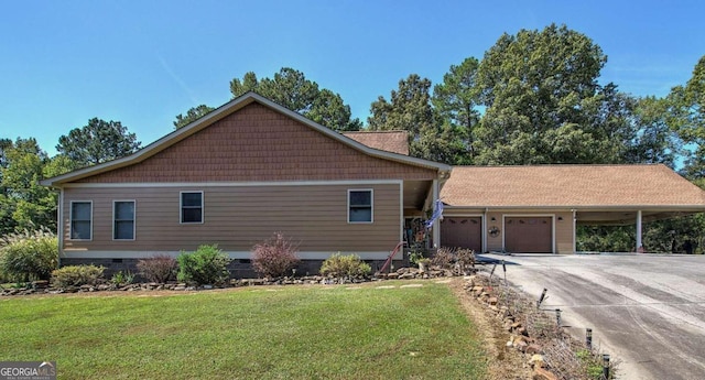 view of front facade featuring a front yard, a garage, and a carport