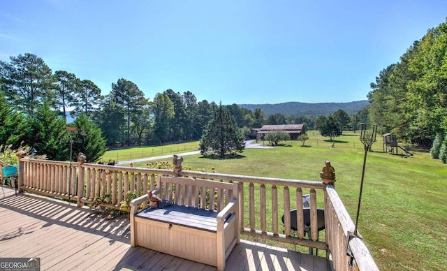 deck with a mountain view and a yard