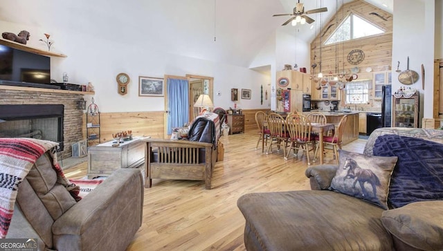 2051 Little Texas Valley Rd, Rome, GA 30165 - living room featuring light wood-style floors, high vaulted ceiling, a fireplace, a ceiling fan, and wooden walls