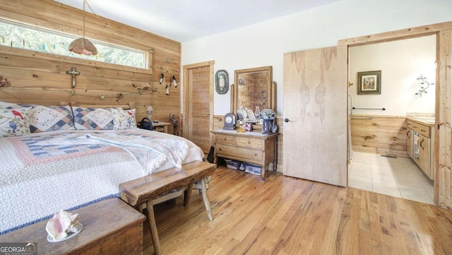 bedroom with light wood-type flooring and wood walls