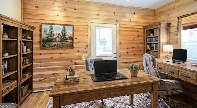 office featuring rustic walls, light hardwood / wood-style floors, and plenty of natural light