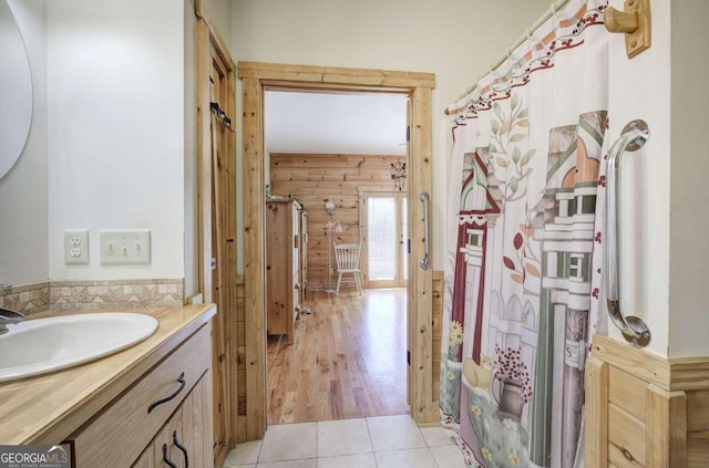 bathroom featuring curtained shower, wooden walls, vanity, and hardwood / wood-style floors