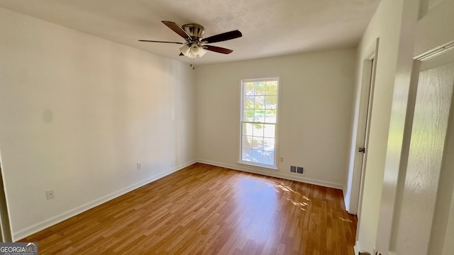 empty room with hardwood / wood-style flooring and ceiling fan