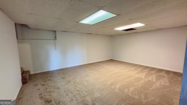 basement featuring a drop ceiling and carpet floors