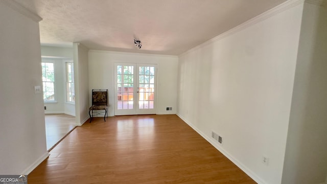 interior space with french doors, plenty of natural light, and hardwood / wood-style floors