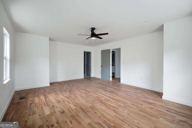 empty room with light hardwood / wood-style flooring, ceiling fan, and a healthy amount of sunlight