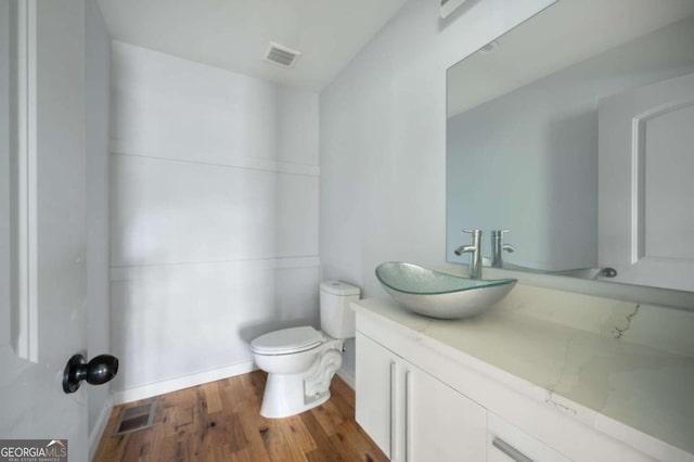 bathroom featuring vanity, toilet, and wood-type flooring