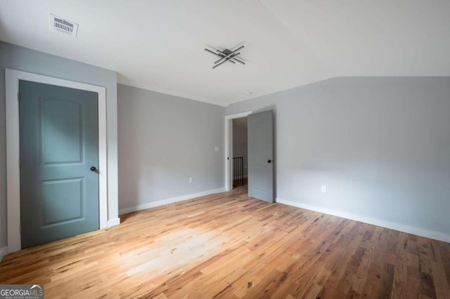 unfurnished bedroom featuring light hardwood / wood-style floors and vaulted ceiling