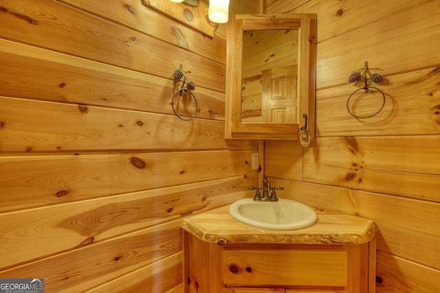 bathroom featuring vanity and wooden walls