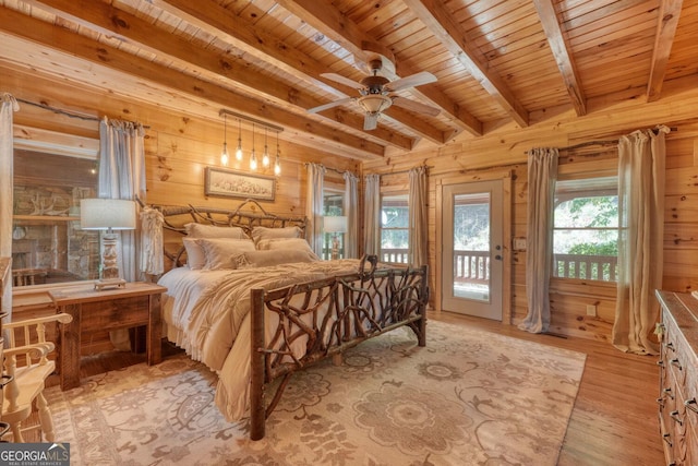 bedroom featuring light wood-type flooring, beamed ceiling, access to exterior, wood walls, and wooden ceiling