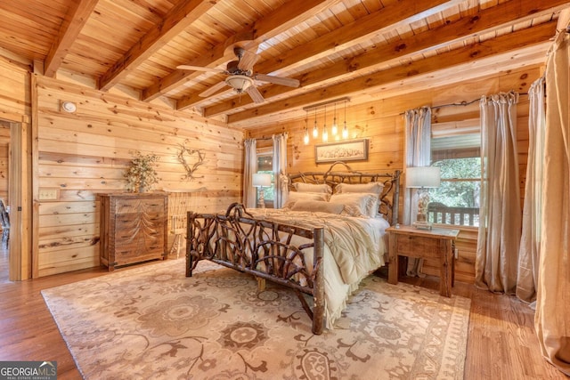 bedroom with wood ceiling, wood-type flooring, beam ceiling, ceiling fan, and wooden walls