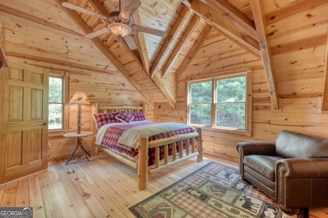 bedroom with ceiling fan, hardwood / wood-style flooring, wooden walls, and multiple windows